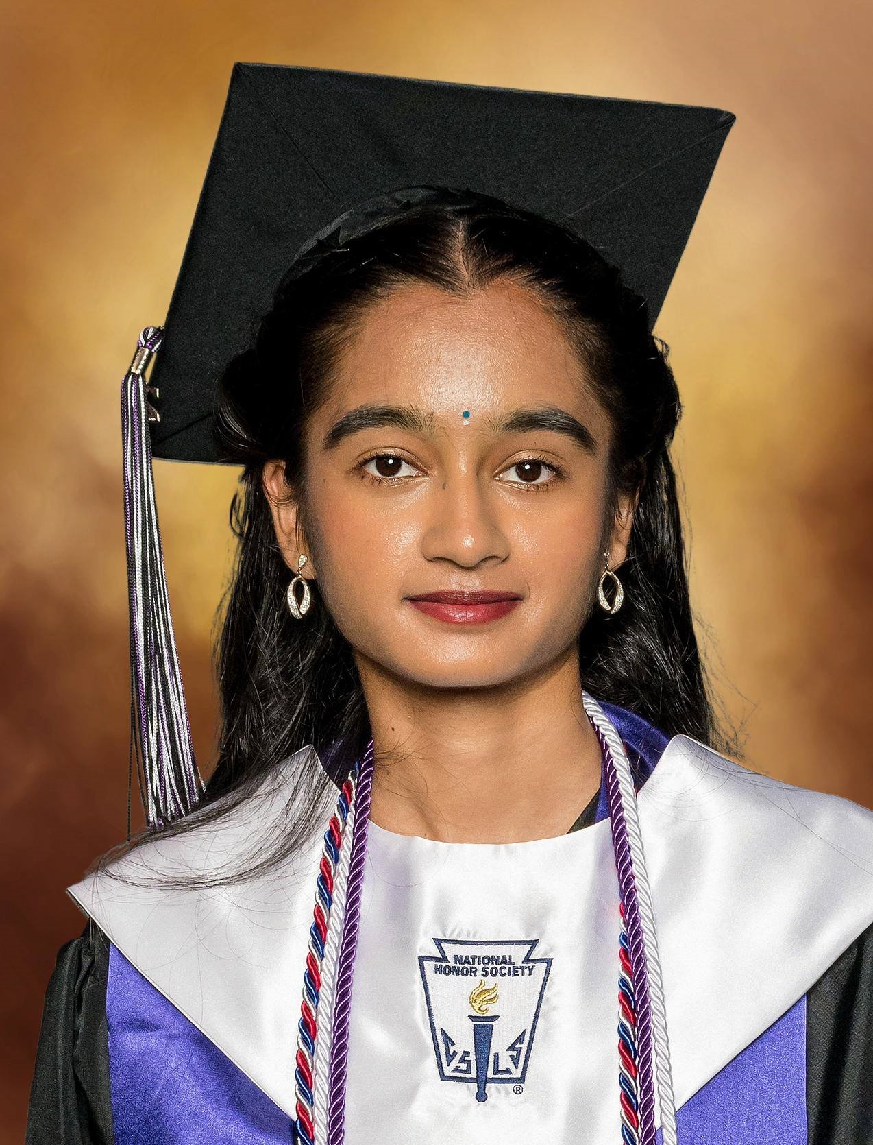 Graduation portrait of me wearing my cap, gown, stoles, and honor cords.